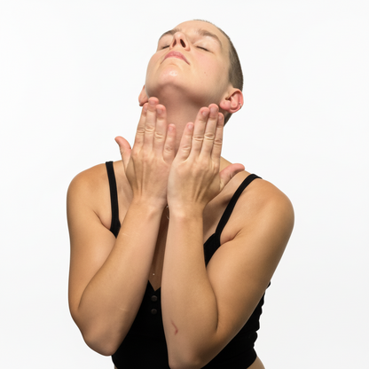 Woman massaging Illumia Shea Butter into neck and jaw — raw plant fats and natural ceramides clinically restore the skin barrier, lock in moisture, and visibly plump dry skin.
